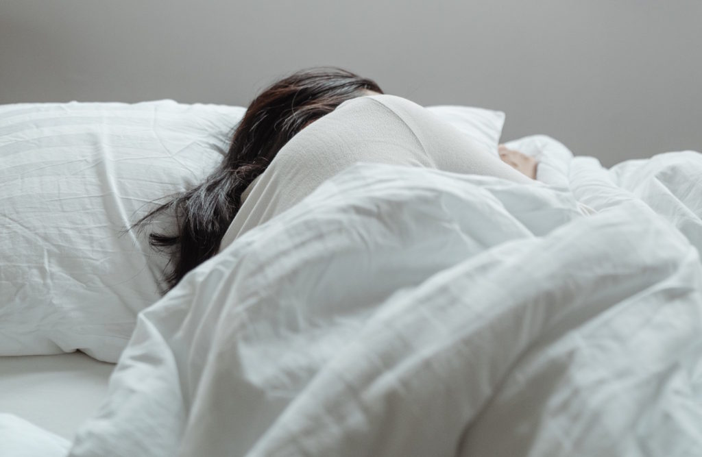 Photo of a person sleeping on a pillow, which can demonstrate that pillowcase can cause acne breakouts