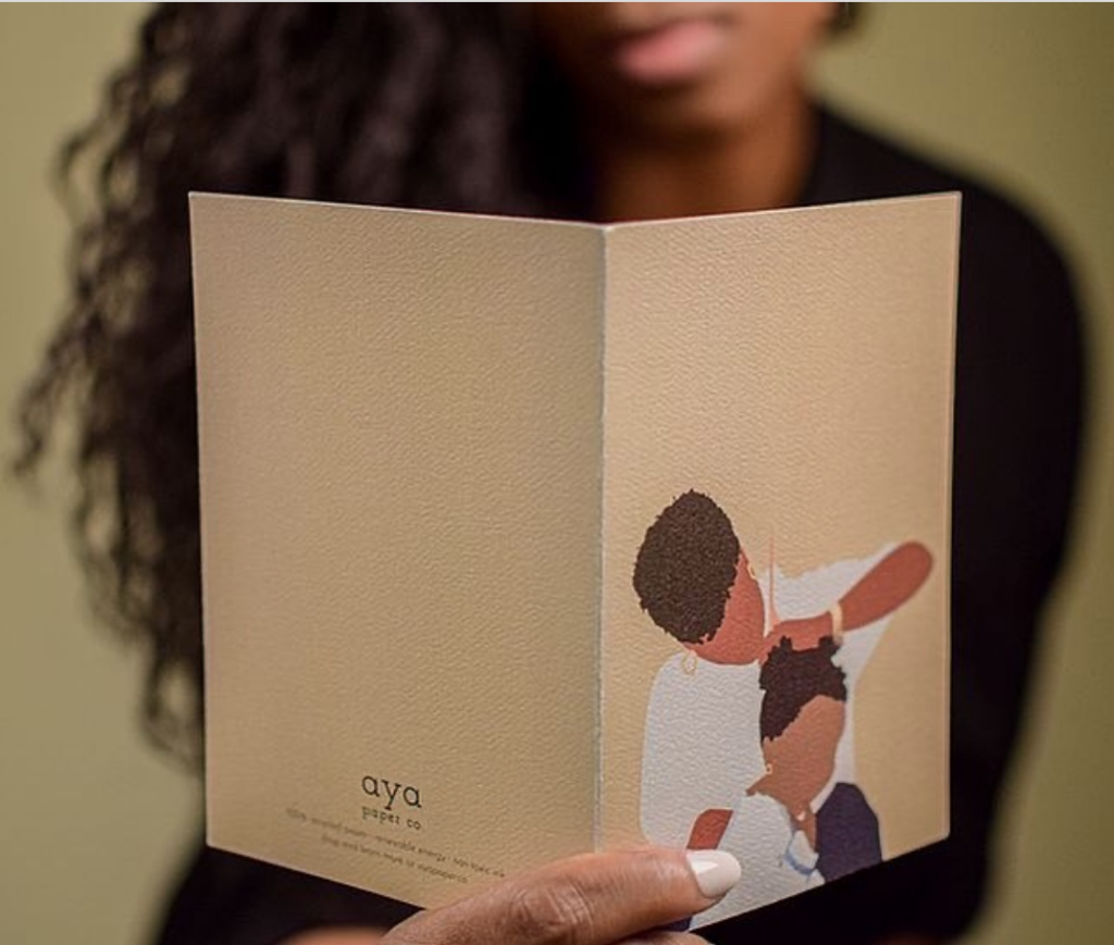 Photo of a woman holding a card from Aya Paper Co